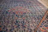 Finely woven vintage Farahan Sarouk rug's intricate madder red and navy henna pattern.