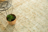 Vintage Kerman carpet's intricate floral vinery in muted ivory, showing mostly even wear.