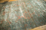 Distressed pile of the vintage Lilihan carpet showing faded teal and raspberry floral motifs.