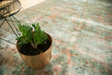 Close detail of vintage Lilihan carpet with worn texture, visible foundation, and time-softened hues.