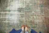 Distressed antique Kerman carpet, showing seafoam, blush, and ivory floral patterns with exposed foundation.