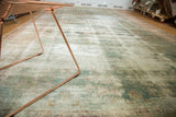 Distressed antique Kerman carpet with faded sea foam green, ivory, and blush floral motifs.