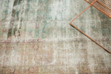 Antique Kerman carpet close-up with even distress, exposed foundation, and faded floral patterns.
