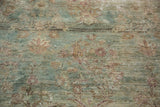 Worn antique Kerman carpet detail, showing sea foam green, blush florals, and ivory foundation.
