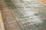 Antique Kerman carpet, distressed with faded blues, greens, rose palmettes, and exposed foundation.
