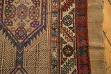 Antique Serab rug detail: original side cord selvage with geometric red and blue borders.