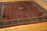 Navy blue main border with European-influenced design and cherry brick red Herati field.