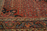 Intricate European influenced border and herati motif in cherry brick red, navy, and green.