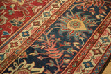Antique Mahal rug detail: ornate navy blue border, gold cartouche, cherry red vinery.