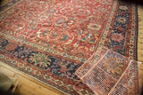 Antique Mahal carpet corner showcasing cherry red scrolling arabesques and navy floral border motifs.