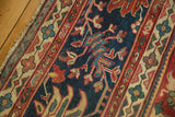 Intricate scrolling vinery motif in cherry red, teal, and saffron on navy Mahal rug.
