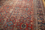 Vintage Mahal carpet detail: cherry red field with time-softened palmette design and navy border.