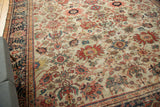 Corner detail of antique Sultanabad carpet, worn ivory field with splayed palmettes, navy border.