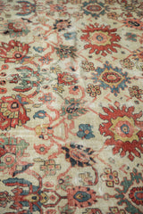 Antique Sultanabad rug: splayed palmettes, ivory field, primary floral motifs, worn pile.