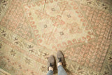 Vintage Oushak carpet with blush quatrefoil medallion and even wear to pile.