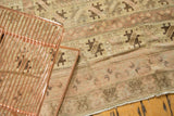 Vintage Oushak carpet, showing worn texture and faded beige, blush, brown floral motifs.