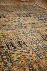 Hand-knotted Bakhtiari carpet detail showing garden of paradise panel motifs in warm beige and deep blue.