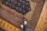 Vintage Kurdish rug's navy field, geometric medallions, and detailed borders in chestnut, blush, ivory.