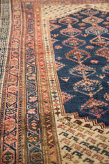 Hand-knotted vintage Kurdish rug's detailed geometric border in pale blush, chestnut, and indigo.