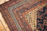 Vintage Kurdish rug corner showing hand-knotted short pile and geometric navy, blush, ivory borders.