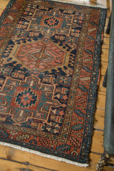 Vintage Karaja rug with geometric border in navy, blush, and green, showing its polychrome side selvage.