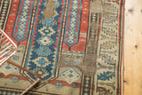 Geometric patterns and rewoven foundation of antique Caucasian rug in beige, blue, and brown.