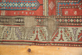 Professional rewoven foundation visible on antique Caucasian rug with geometric bands.