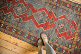 Textured madder root red and indigo blue geometric medallions on this antique Caucasian Kazak runner.