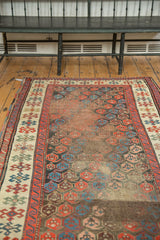 Antique Karabagh runner, with staggered boteh pattern in madder red, indigo blue, ivory, and visible wear.