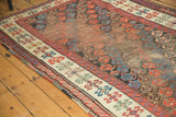 Antique Karabagh runner field with staggered botehs, time-softened hues, and a vibrant geometric border.