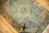 Distressed vintage Hamadan rug in soft sky blue, sand, and brown tones with faded medallion pattern.