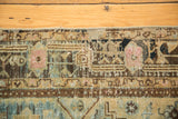 Distressed vintage Hamadan rug detail: secured side, rectilinear floral design, and worn texture.