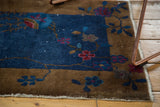 Fringed edge of an antique Fette Li rug, with art deco floral motifs and blue field.