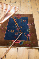 Art Deco stylized floral and bird motifs on antique Chinese Fette Li rug in navy and brown.