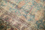 Close-up of distressed antique Khorassan carpet showing faded blue, ivory palmettes, and foundation wear.