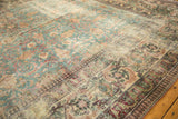 Distressed antique Khorassan rug with faded denim blue field and worn ivory sections, revealing stylized patterns.