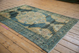 Abrashed faded blue field with ivory rococo outlines on a vintage Hamadan rug corner.