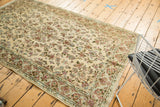 Intricate floral pattern and border of vintage Kerman rug in ivory, red, blue, green.