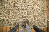 Vintage Persian Kerman rug featuring intricate floral designs in ivory, blues, greens, and reds.