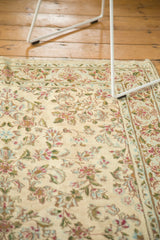 Intricate hand-knotted floral pattern with even wear on a vintage Kerman rug's ivory field.