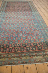Vintage Serbend rug runner's repeating staggered boteh motifs in dusty raspberry and blue.
