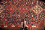 Antique Qashqai rug detail: dense tribal patterns, animals, and plants.