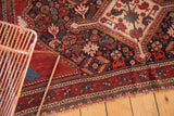 Antique Qashqai rug with pictorial birds, animals, floral motifs in burgundy, navy, fringed edge.