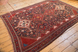 Hand-knotted antique Qashqai corner, wine red border, fringed edge, geometric motifs, light wear.