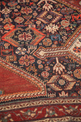 Intricate stylized patterns on navy field and patterned red border of antique Qashqai rug.