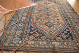 Vintage Kamseh rug featuring apricot, navy diamond, pinwheel, and rams horn motifs.