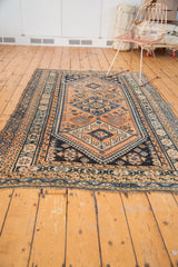 Apricot and navy blue geometric border with secure fringe on a vintage Kamseh rug.