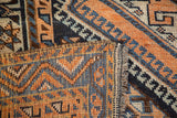 Hand-knotted Kamseh rug texture with geometric apricot and navy pattern, showing fringe.