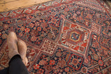 Antique Qashqai rug's navy and madder root field with intricate stylized plants and geometric designs.