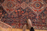 Ornate field detail of antique Qashqai rug with geometric medallion, stylized plants, animals.